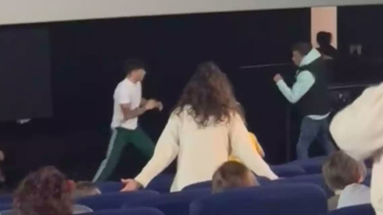Dos hombres se pelean en el cine delante de varios niños