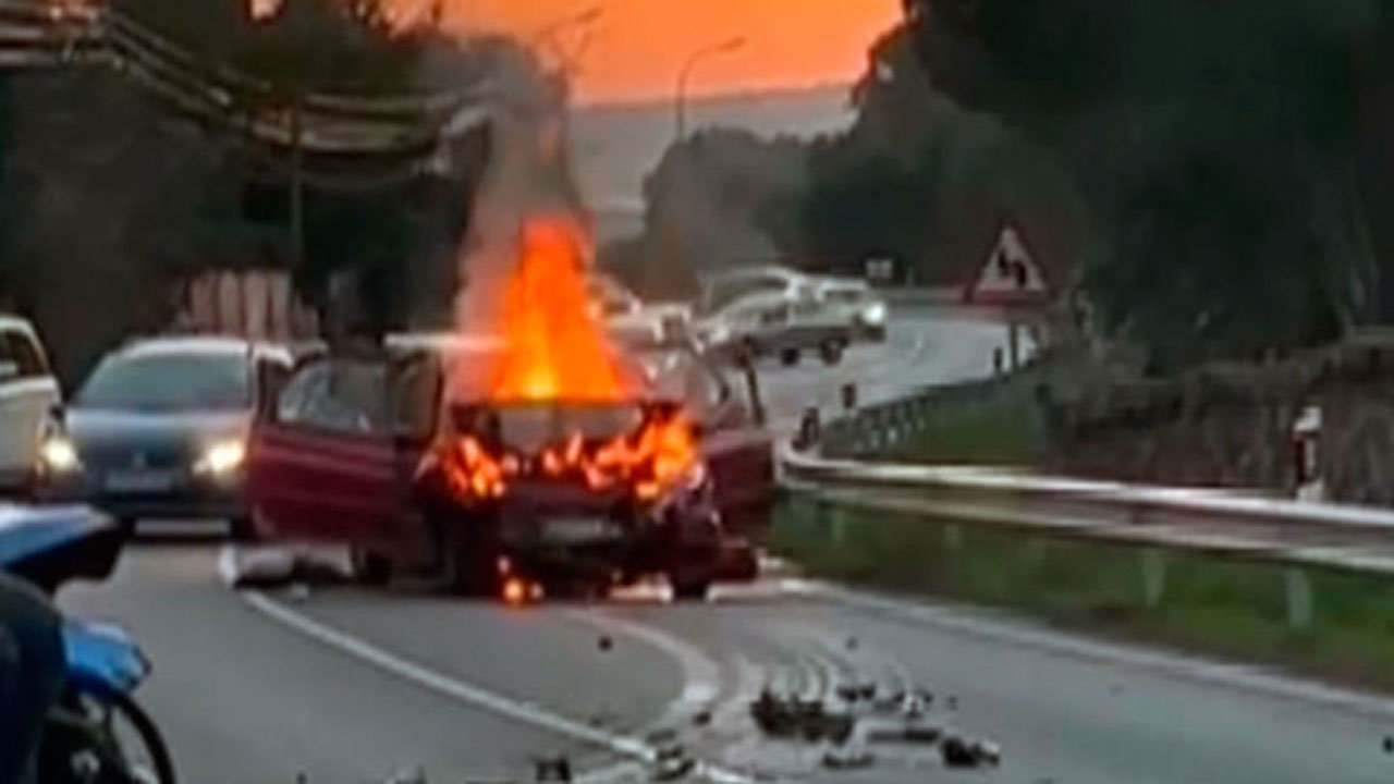 Imagen del vehículo ardiendo tras el choque frontal contra otro coche.