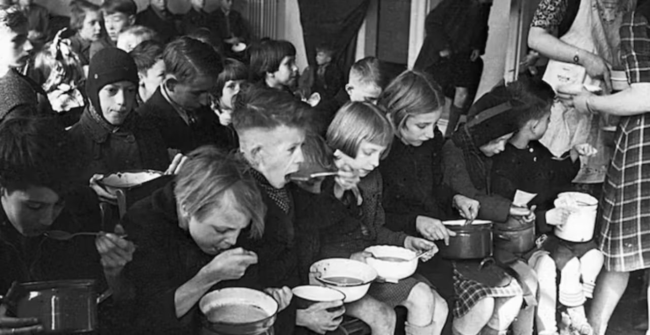 [Dar clic y arrastrar para mover]
Niños comen alimentos donados por una organización eclesiástica durante la gran hambruna que sufrió Países Bajos entre 1944 y 1945. Menno Huizinga / Wikimedia Commons