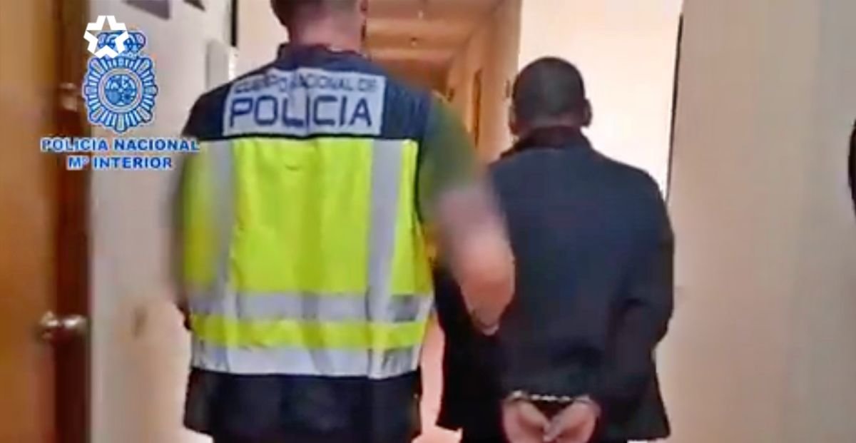 Un agente de la Policía Nacional acompaña al detenido en la comisaría de Fuenlabrada