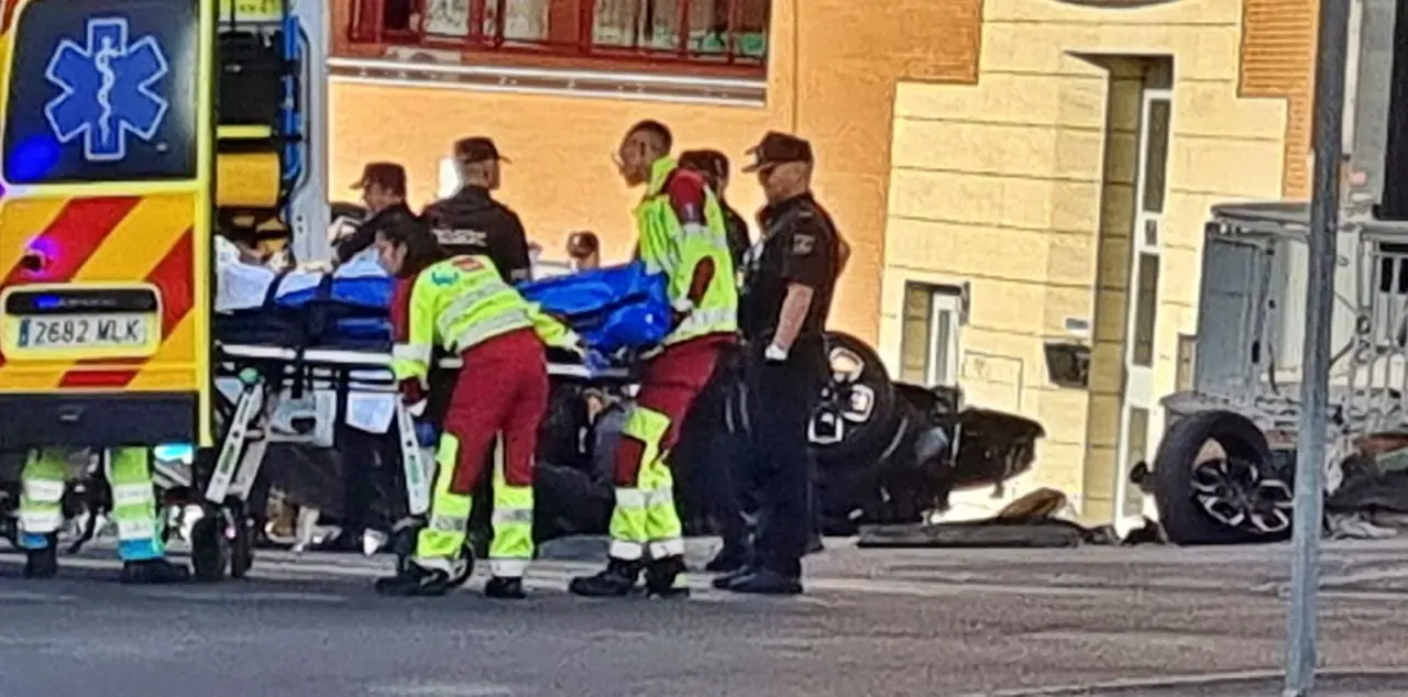 Una ambulacia del 112 recoge a uno de los heridos, tras volcar el veh&iacute;culo sustraido