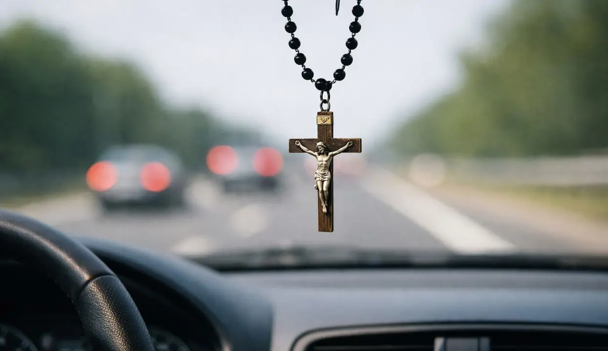 Crucifijo colgado en el espejo del coche