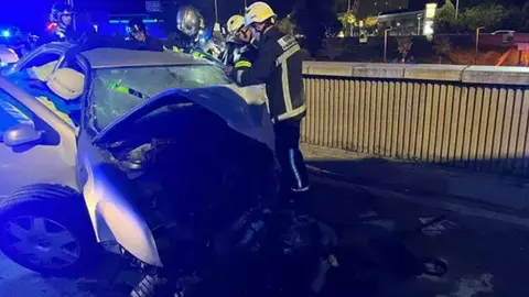 Imagen de los bomberos realizando labores de rescate en el veh&iacute;culo accidentado. Foto: Emergencias 112