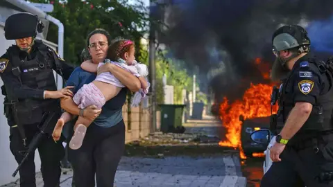 Una mujer corre hacia un refugio ayudada por soldados israel&iacute;es, tras los ataques de Hamas | AFP