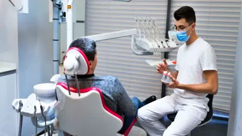 Un paciente hablando con el profesional ortodentista