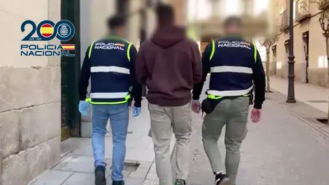 Uno de los implicados, escoltado por dos agentes tras ser detenido | Polic&iacute;a Nacional