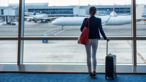 Mujer en el aeropuerto con su equipaje de mano | depositphotos.com
