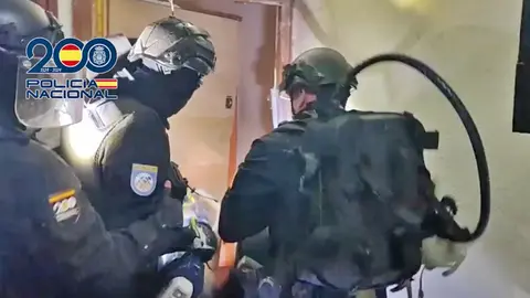 Agentes de la Polic&iacute;a Nacional entrando en una vivienda para desmantelar venta de droga en Parla