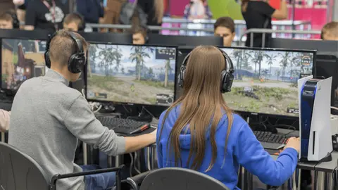 Dos personas jugando a un shooter en el ordenador | Sal&oacute;n del Videojuego