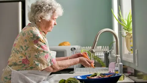 Mujer lavando verduras | unplash.com
