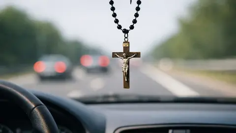 Crucifijo colgado en el espejo del coche